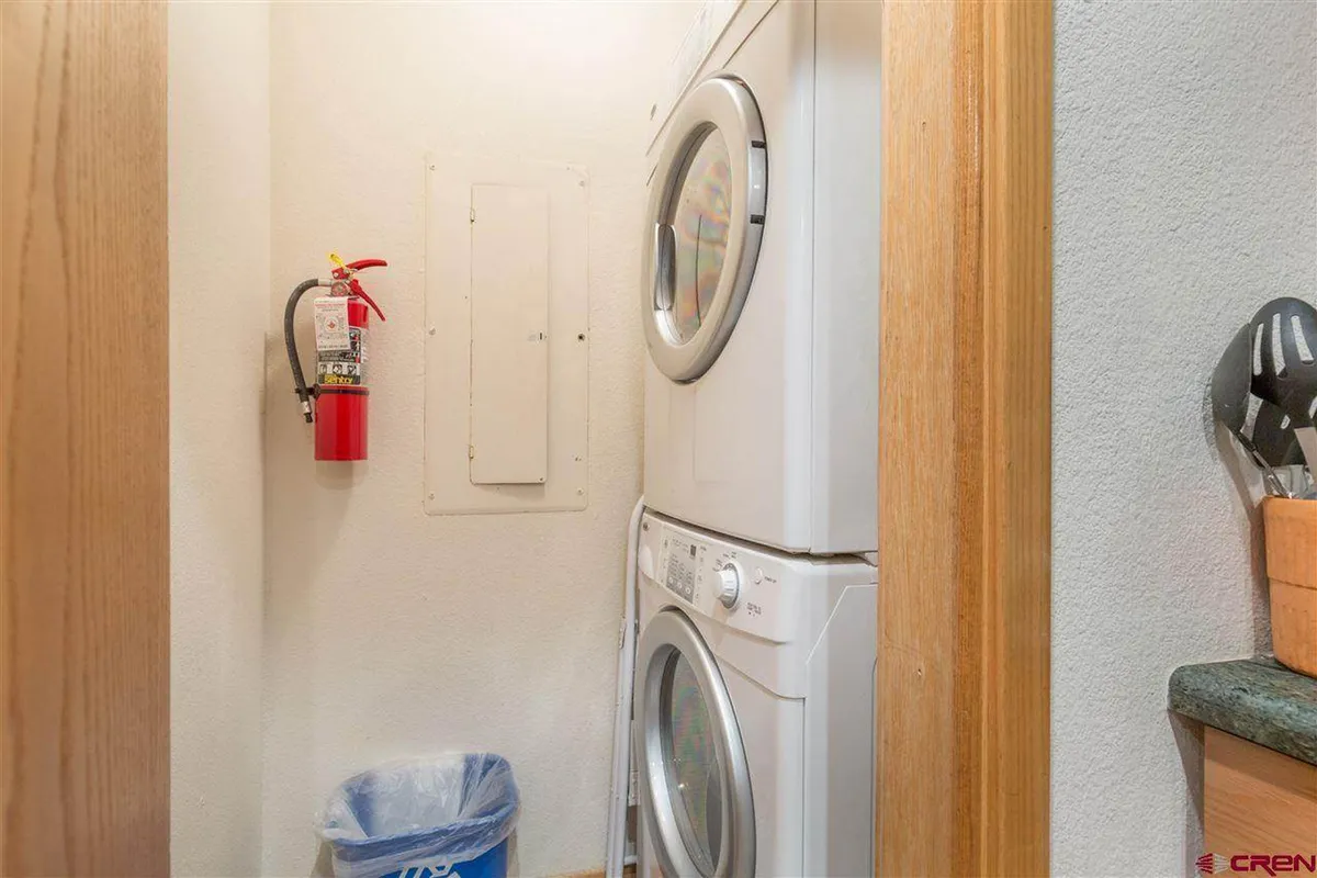 This practical interior photo centers on a stacked washer and dryer in a tidy laundry nook, emphasizing easy in-unit laundry access for guests. The organized look underscores the convenience of home-like amenities.